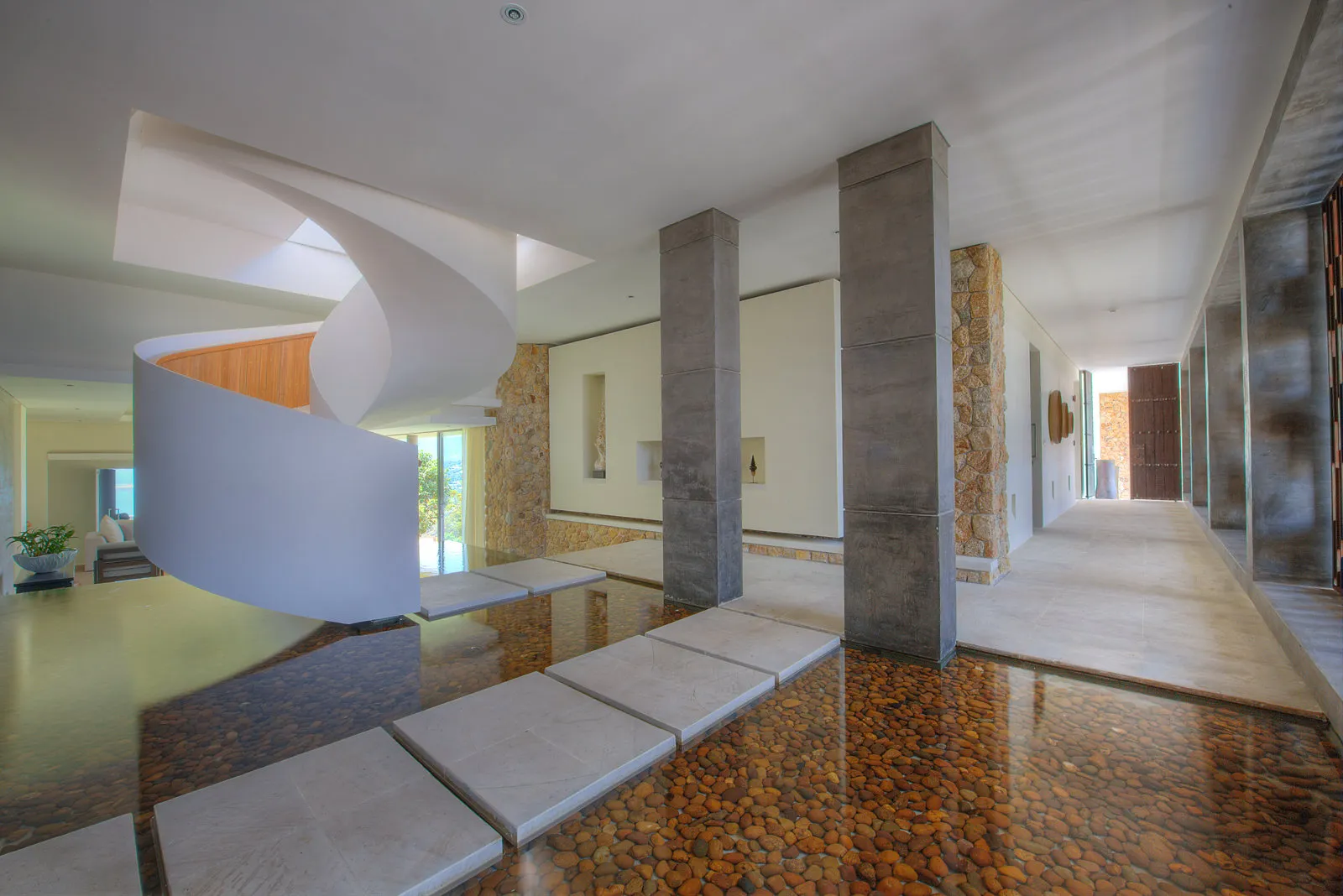 Entrance hallway with spiral staircase and water feature at villa, Koh Samui